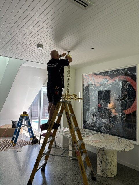 Tim installing a pendant light fitting in a modern Clarence Valley home